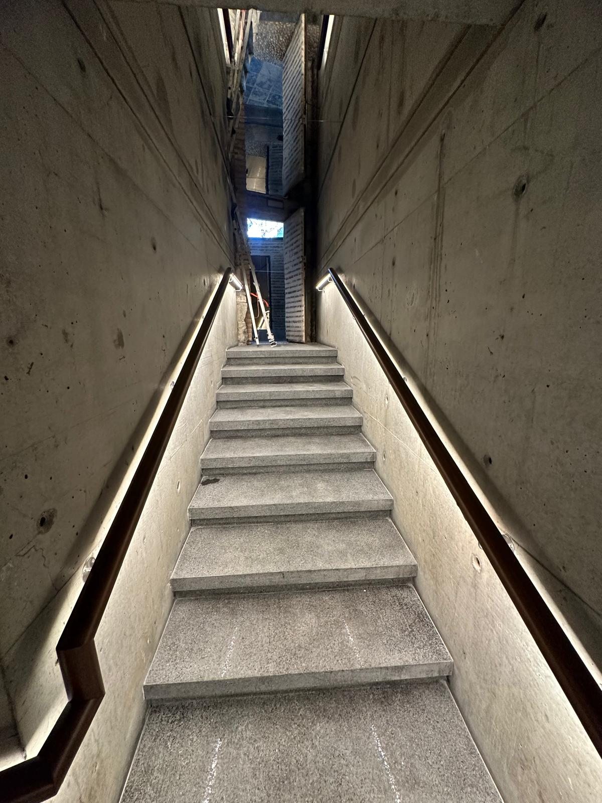 Dar beton merdivende iki yanda aydınlatmalı korkuluklar