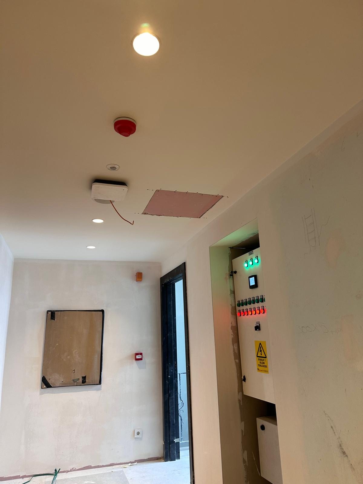 Rezidans koridorunda elektrik panosu, tavan spotları ve uyarı elemanları